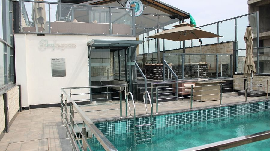 Rooftop swimming pool with a lounge and patio umbrella at BluSalzz Residence, Amritsar.